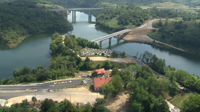 Aerial helicopter shot of a road, highway and bridge across a river