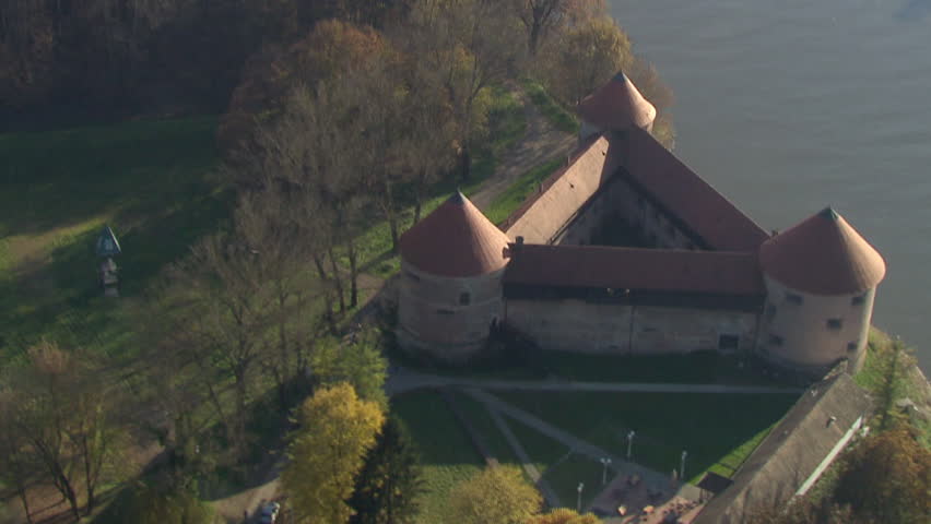 A castle on riverbank. Aerial helicopter shot.