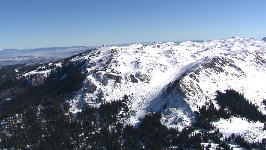 Aerial shot of a top of mountain Jahorina covered by snow in a bright day