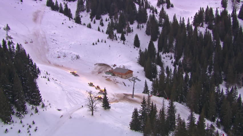 Aerial shot of the ski center on the mountain Jahorina at dawn with snowplows in