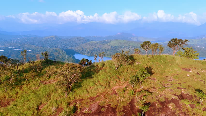 Coming closer to the edge of the mountain. Revealing view on the beautiful azure waterscape among the hills. Sri Lanka, South Asia.