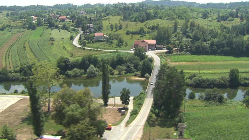 Flying over beautiful green landscape with a river flowing. Aerial helicopter