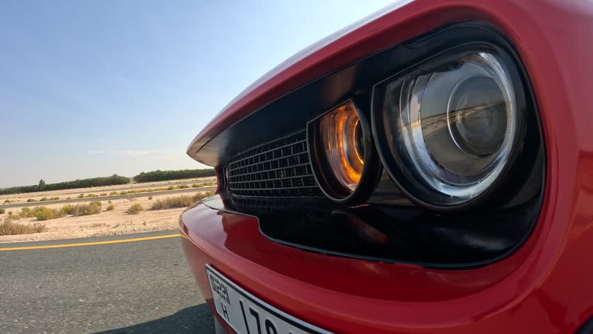 a red muscle car on the road
