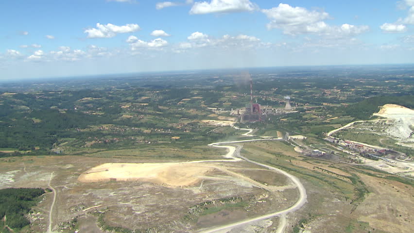 Coal fields and constructing machines near power plant. Aerial shot.
