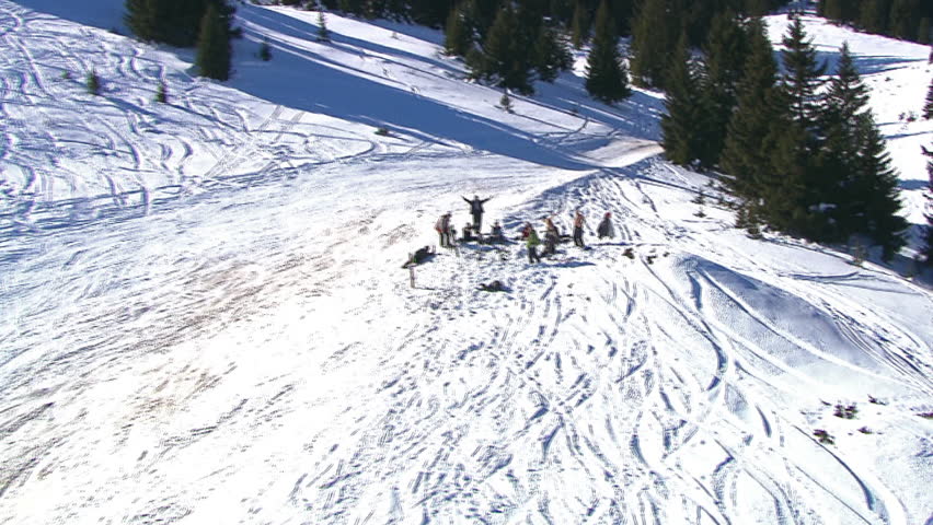 Aerial shot of people skiing and a group of people waving, mountain Jahorina