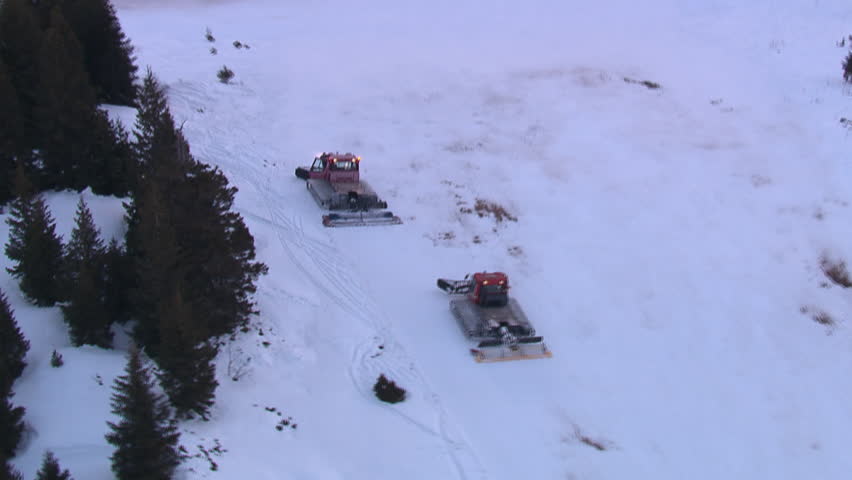 Aerial shot of the ski center on the mountain Jahorina at dawn with snowplows