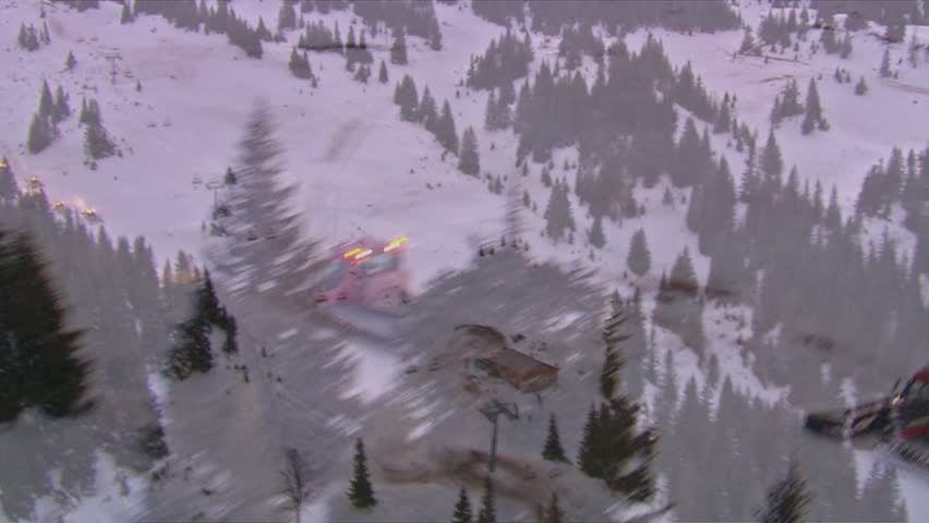 Aerial shot of the ski center on the mountain Jahorina at dawn with snowplows in