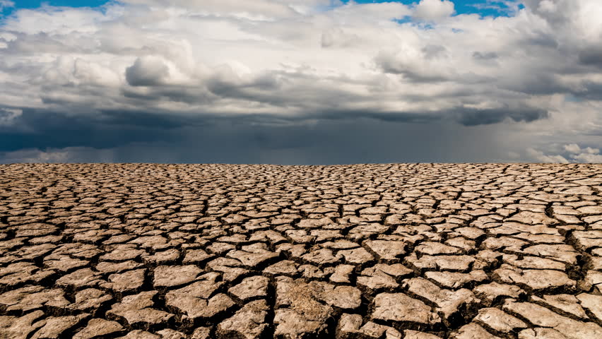 Rain clouds over cracked ground. Drought, environmental issues