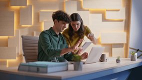 Woman boss showing tablet to man professional working at laptop in creative agency office. Two coworkers discussing digital project in workplace environment. Colleagues planning teamwork collaboration - Powered by Shutterstock - Get 15% off with code: PIKWIZARD15