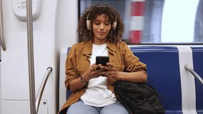 Young woman listening to music with headphones while riding the subway, captured in slow motion during her daily commute to work - Powered by Shutterstock - Get 15% off with code: PIKWIZARD15