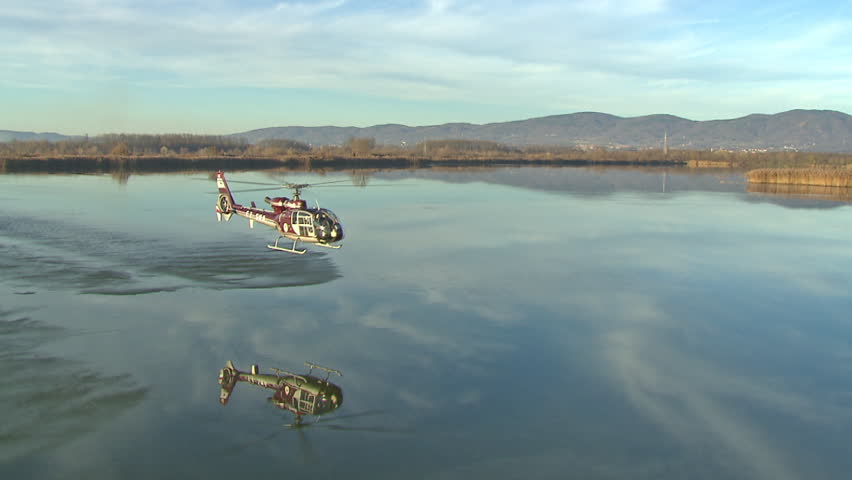 Aerial shot of a helicopter flying over the water