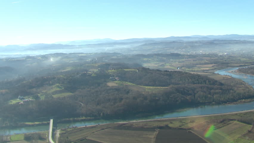 Aerial helicopter shot of a river valley and waterlands in rural area