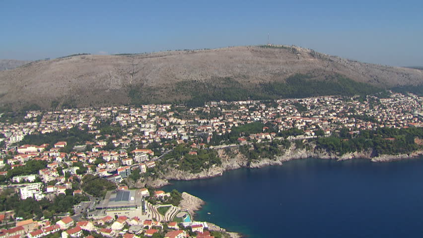 Helicopter flying slowly along the Adriatic coast and approaching to the famous