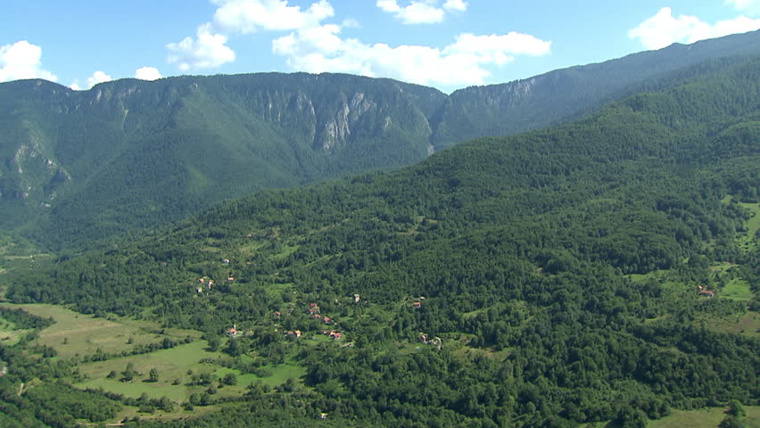 A high altitude flight over green slopes of Dinaric Alps. Aerial helicopter