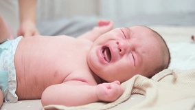 Asian baby boy is lying on the bed and crying. The kid put his hand or fist in his mouth - Powered by Shutterstock - Get 15% off with code: PIKWIZARD15