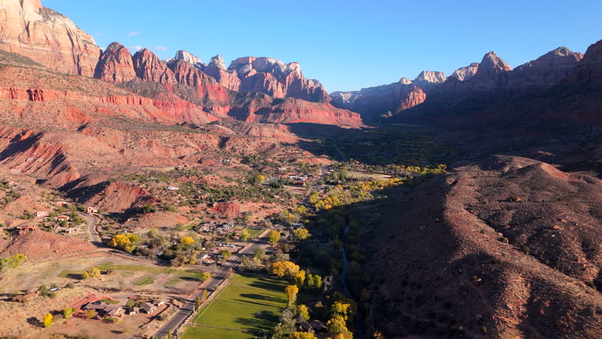 The breathtaking aerial view of Zion National Park displays the stunning red rock formations and lush, green valleys, all beautifully illuminated during the enchanting sunset hour