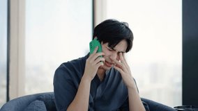 Young Asian man showing sad expression when answering a phone call, Upset guy talking on cellular about solving problem, discuss business failure ask for advice in difficult situation - Powered by Shutterstock - Get 15% off with code: PIKWIZARD15