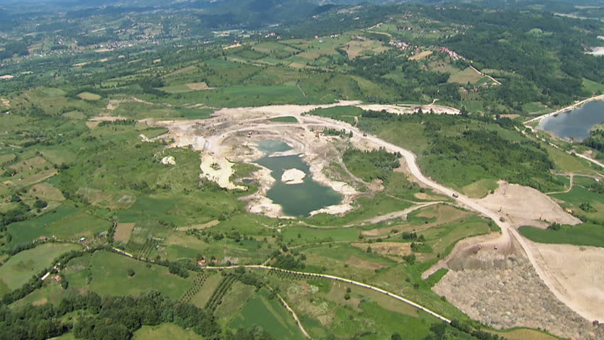 Coal fields and accumulating lake inside green environment. Aerial helicopter