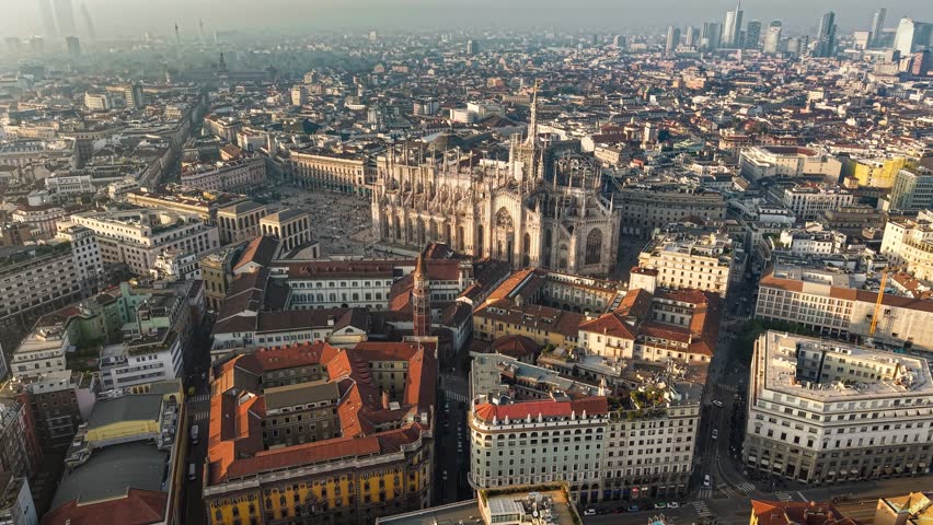Stunning aerial view of Milan showcasing the magnificent cathedral and vibrant cityscape during sunset. Fly near Milan