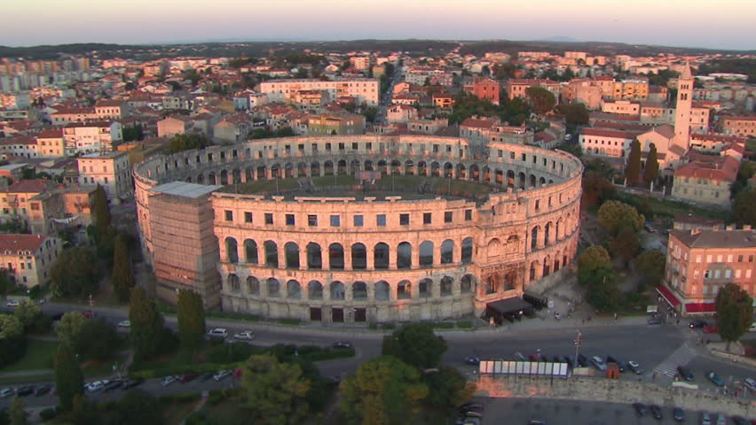 A circling view of the Arena of Pula at sunset. Aerial helicopter shot.