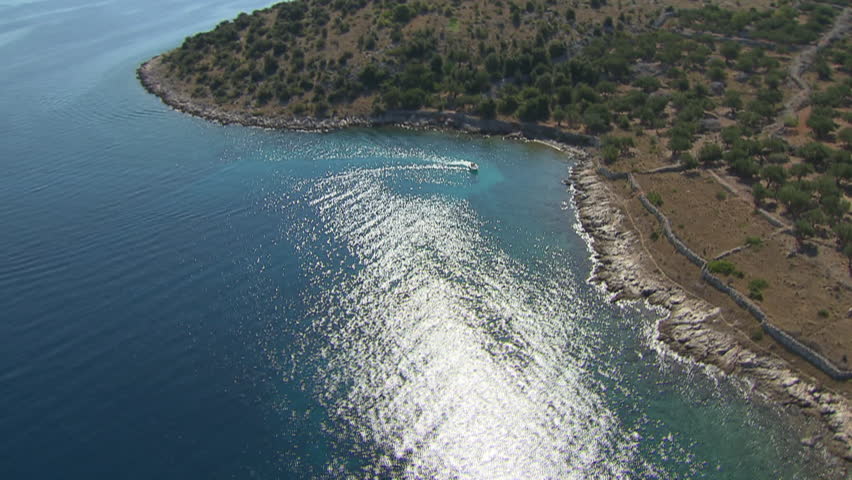 A desolate beach belonging to Kornati archipelago, calm sea and a boat. Aerial