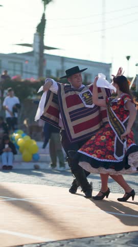 Presentation of a couple of huasos dancing Chilean cueca with the public in the background