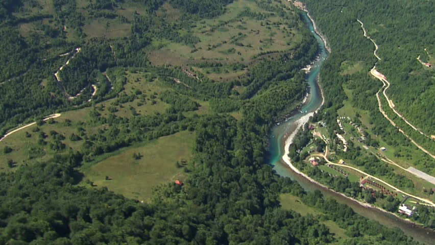 Camera showing beautiful green hills and river Drina, then zooming-in to a
