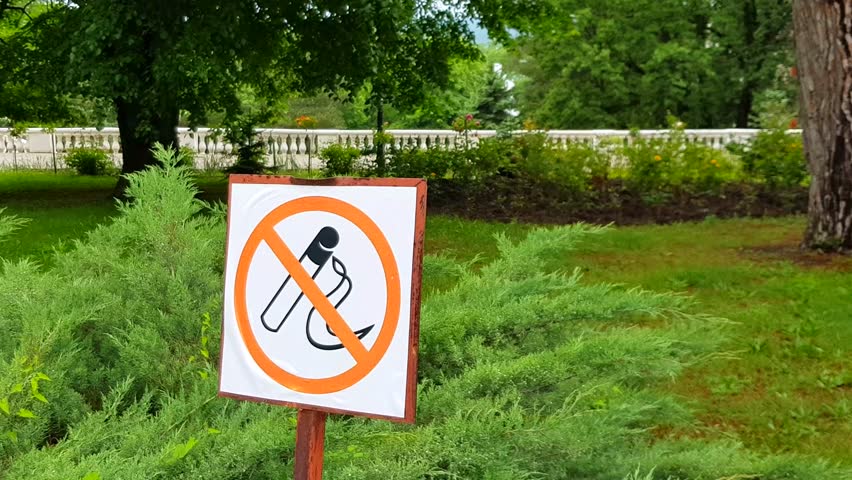 4k video, NO SMOKING sign in the summer park against the background of alleys and trees, the concept of banning smoking in public places.