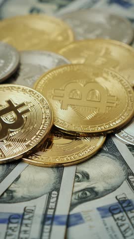 Golden bitcoins BTC rotating on dollars bills. Investments and finance. Cryptocurrency. New virtual money. Crypto mining. Digital currency bitcoin. Vertical video