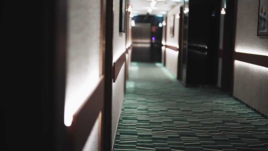 Establishing shot of luxury hotel corridor. The hallway is lit up with lights
