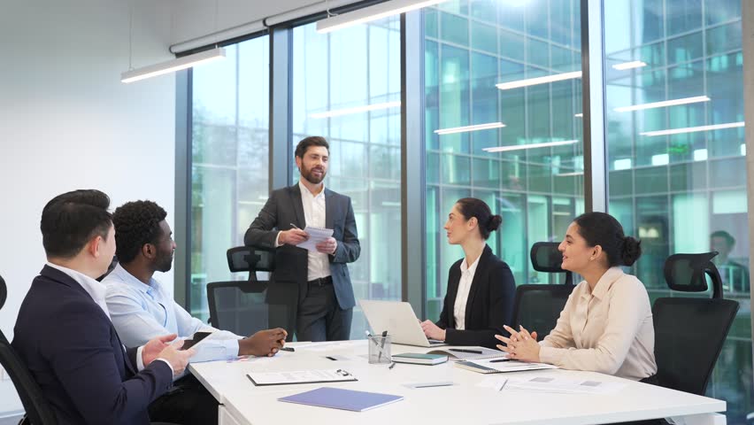 Group of business people meeting in office. Diverse corporate team of professionals in suits discussing strategy or startup. Brainstorming briefing co-workers colleagues communicate at conference 