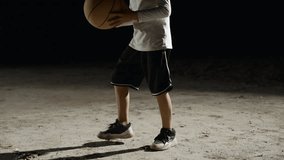 Child practicing basketball skills at night on an outdoor court showcasing family bonding and sports enthusiasm - Powered by Shutterstock - Get 15% off with code: PIKWIZARD15
