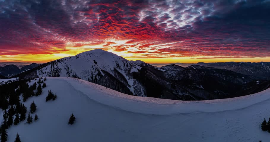 Epic sunrise with red bloody clouds sky over winter alps mountains landscape Aerial view