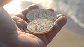 Man holding Bitcoin BTC coins in hand on background sea waves on sandy beach on sea shore on sunny day. Concept cryptocurrency money cryptography cryptocurrencies bitcoins. Peer-to-peer payment web 3 - Powered by Shutterstock - Get 15% off with code: PIKWIZARD15