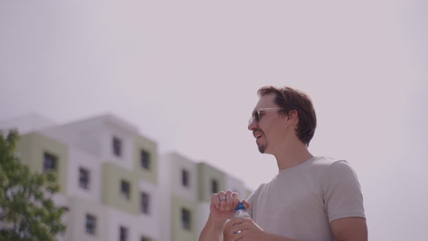 Man opening a bottle of water in hot weather
