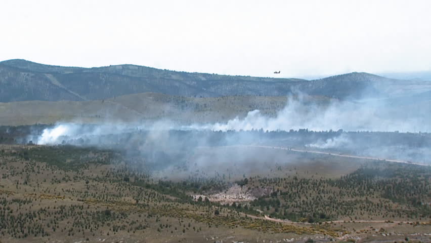 An aircraft extinguishing fire. Aerial helicopter shot.