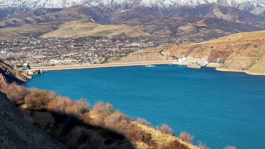 Water reservoir in the mountains with snowy peaks