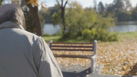 Senior man enjoys an autumn day, seated peacefully on a bench in a park with fallen leaves surrounding him, capturing a moment of tranquility. - Powered by Shutterstock - Get 15% off with code: PIKWIZARD15
