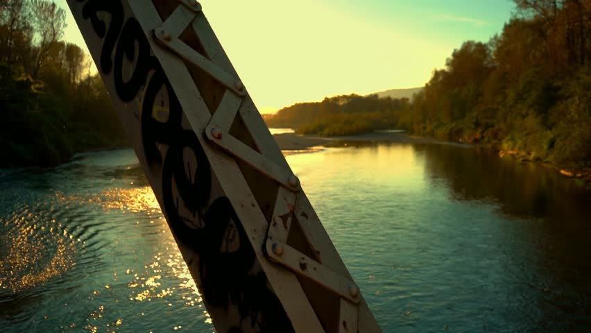 Slow Motion sun flare on train bridge with graffiti 