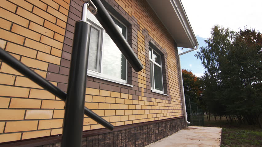 Wall of brick house with modern plastic windows and mosquito nets. Renovation of public facilities in suburban area. Suburban development