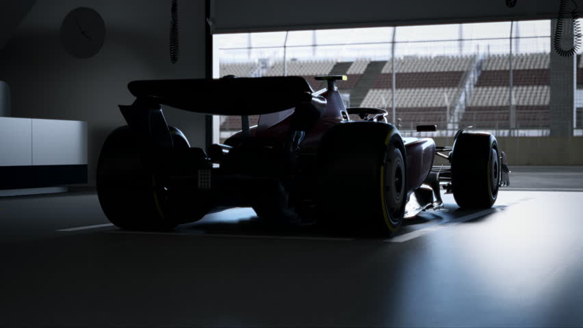 Silhouette of a race car in a dimly lit garage with soft light streaming through, garage door opens