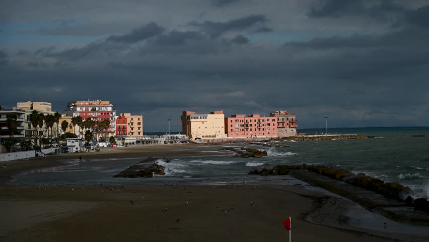 Anzio, Italy: Buildings by the sea. Italian coastline. Waves on Tyrrhenian sea. 