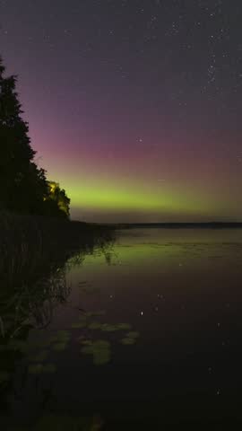 The aurora borealis dances across the night sky, painting it with vibrant waves of green, purple, and gold.
