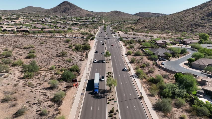 Aerial view of suburban homes and traffic along Shea Blvd with dry desert mountains in the background, Scottsdale, United States.