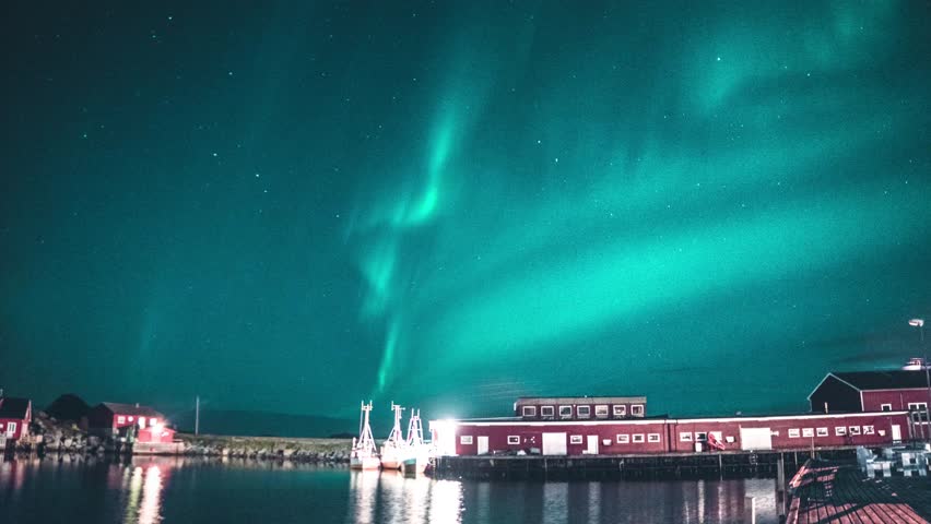 The aurora borealis dances across the night sky, painting it with vibrant waves of green, purple, and gold.