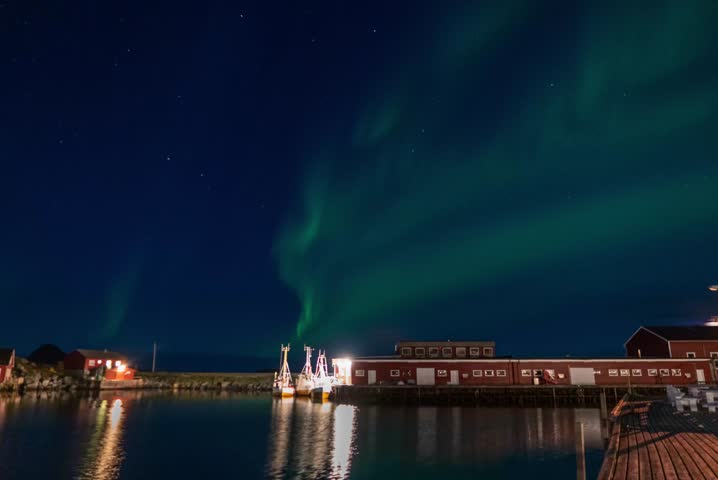 The aurora borealis dances across the night sky, painting it with vibrant waves of green, purple, and gold.