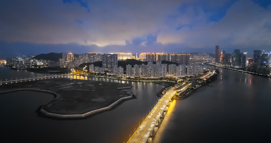 Macau modern city buildings and bridge with sea at night
