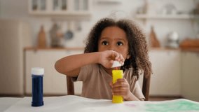 Child playing with soap bubbles, portrait of charming black baby girl at home. Carefree and happy childhood, African American ethnicity, mixed race family, flying bubbles in slow motion, children game - Powered by Shutterstock - Get 15% off with code: PIKWIZARD15