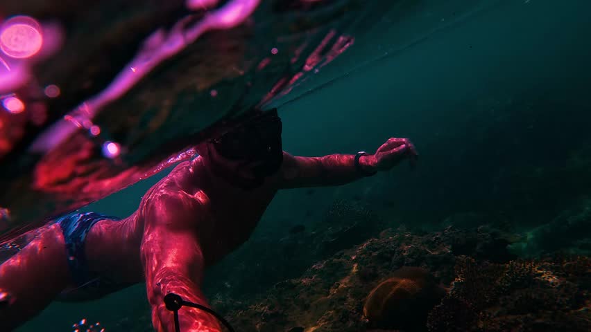 Men dives flippers mask and breathing tube into the water swims. Scuba divers exploring large underwater clear coral reef, tropical ocean.