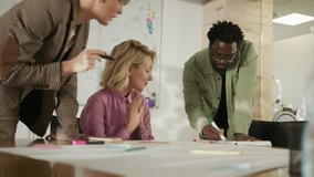 Diverse marketing team collaborates on a project, using a smartphone for reference and brainstorming ideas. The slow motion effect highlights their engagement and teamwork - Powered by Shutterstock - Get 15% off with code: PIKWIZARD15